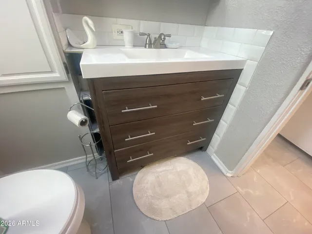 a bathroom with a sink a toilet and a mirror