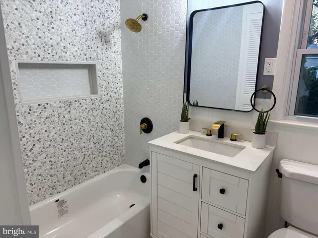 a bathroom with a sink a toilet and mirror