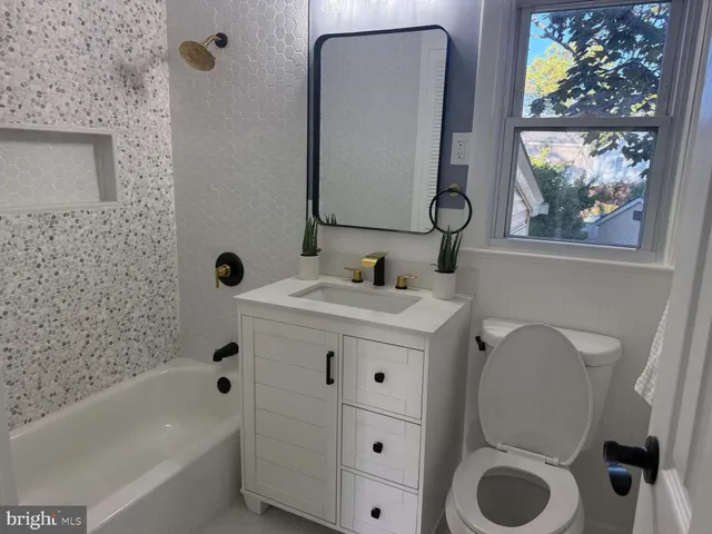 a bathroom with a sink mirror vanity and toilet