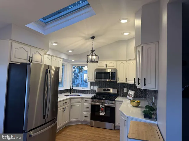 a kitchen with stainless steel appliances a stove a refrigerator and a sink