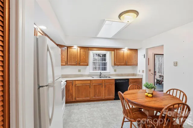 a kitchen with stainless steel appliances granite countertop a sink and a refrigerator