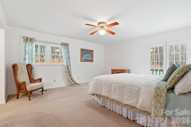 a bedroom with a bed a chair and a large window