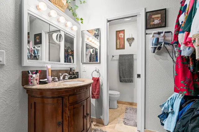 a bathroom with a sink vanity mirror and toilet