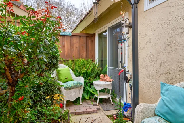 a view of a chair and table in back yard of the house