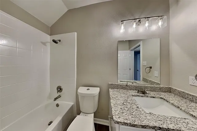 a bathroom with a granite countertop sink a toilet and bathtub