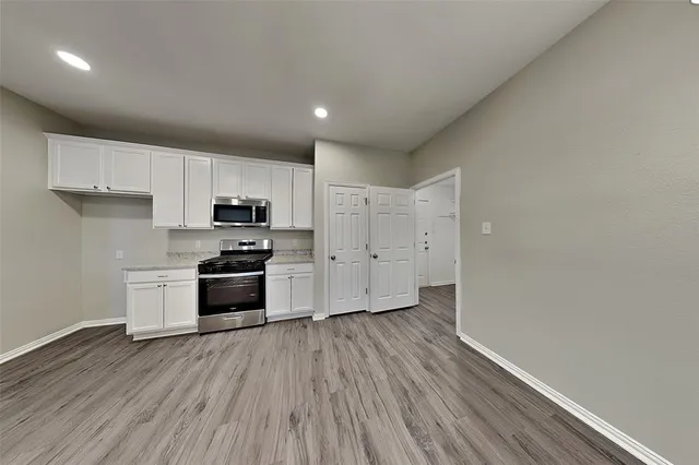 a kitchen with granite countertop a stove a sink and a refrigerator