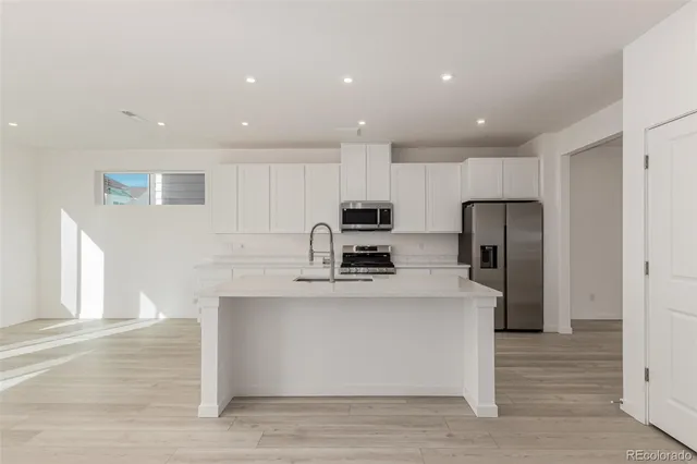 a kitchen with stainless steel appliances granite countertop a sink a stove a refrigerator and a oven