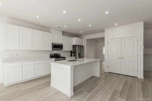 a kitchen with white cabinets stainless steel appliances and sink