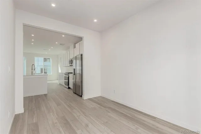 a view of a kitchen with a white cabinets and wooden floor