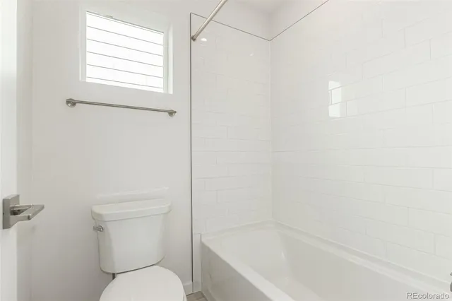 a white toilet sitting next to a bath tub