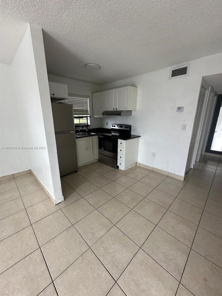 431 East 28th Street, Unit 3 Hialeah, FL 33013 - Photo 6 of 8 a kitchen with a sink and a stove top oven