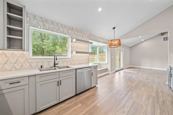 a kitchen with a sink window and cabinets