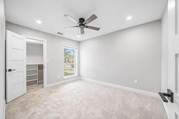 an empty room with closet and windows