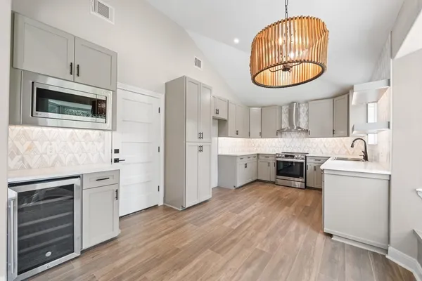 a kitchen with stainless steel appliances a stove a sink and a microwave