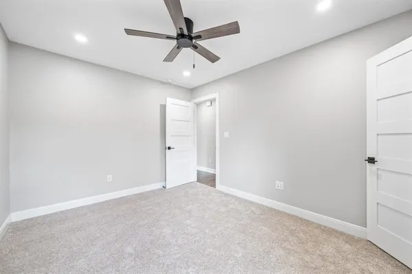 an empty room with a ceiling fan and a window