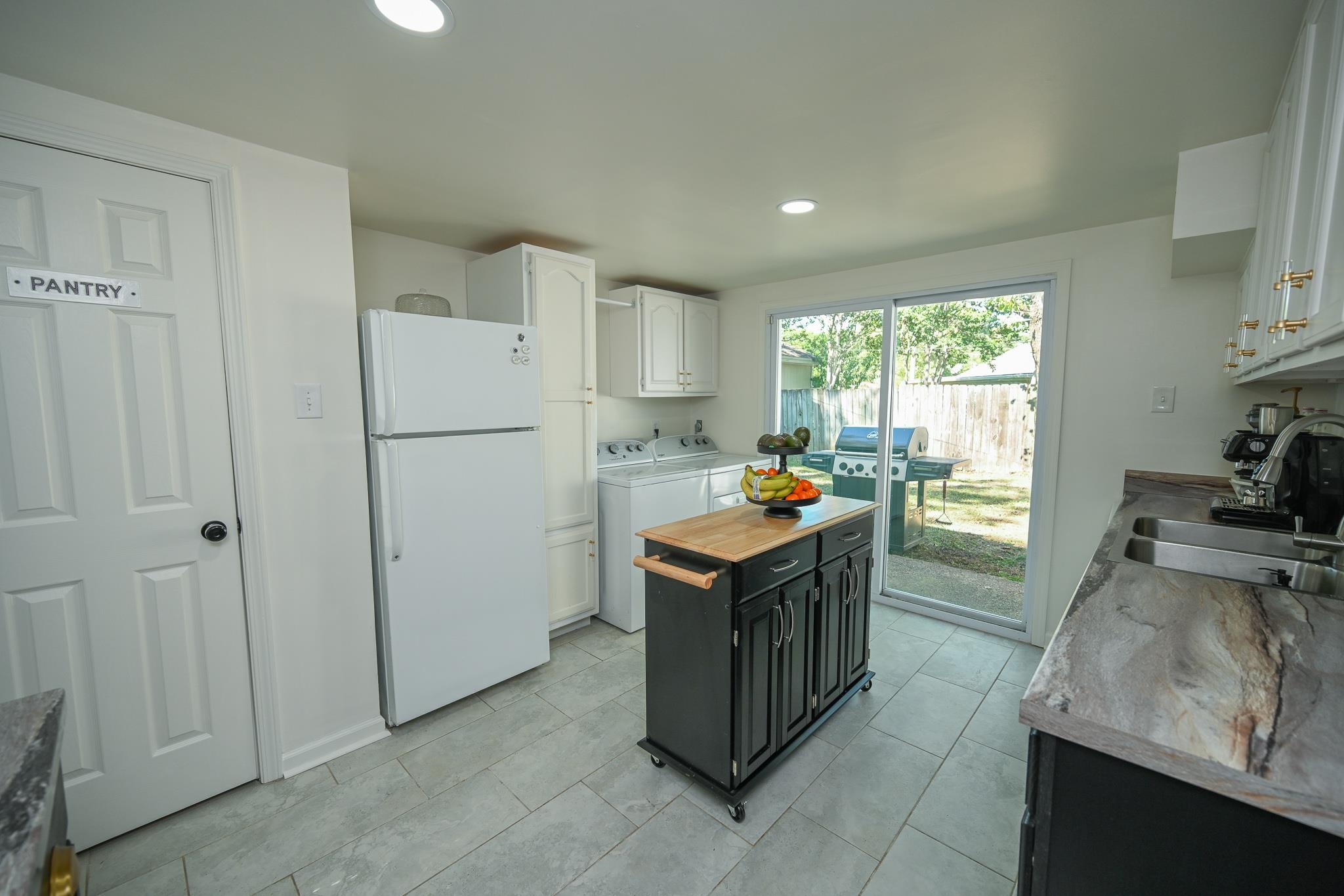 1105 Stratford Road Memphis, TN 38122 - Photo 17 of 26 Kitchen featuring white cabinetry, freestanding refrigerator, dark cabinetry, recessed lighting, and wood counters