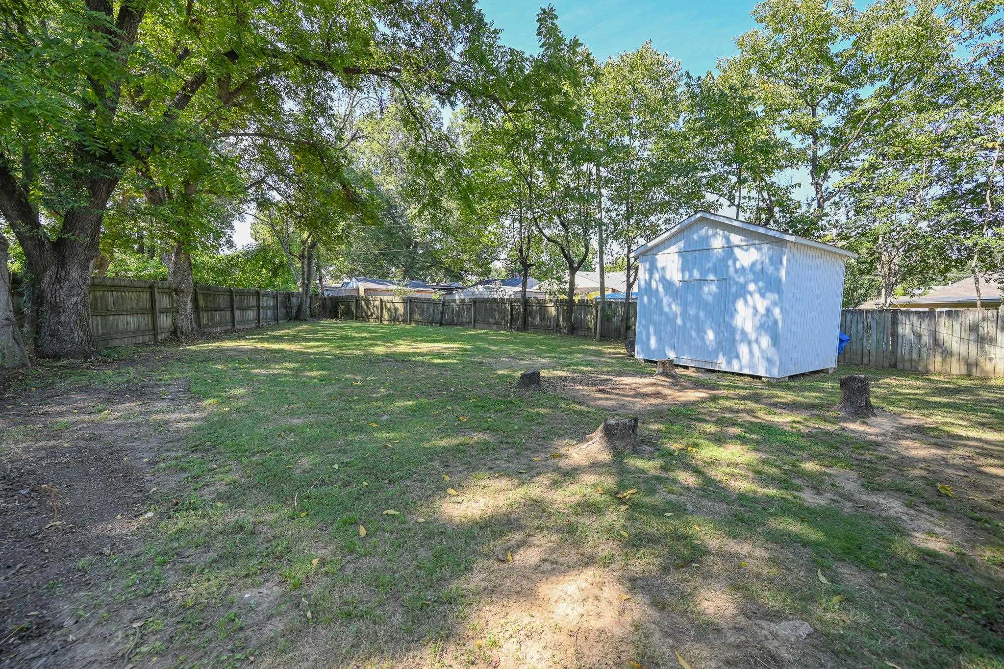 1105 Stratford Road Memphis, TN 38122 - Photo 23 of 26 Fenced backyard featuring a shed and view of scattered trees