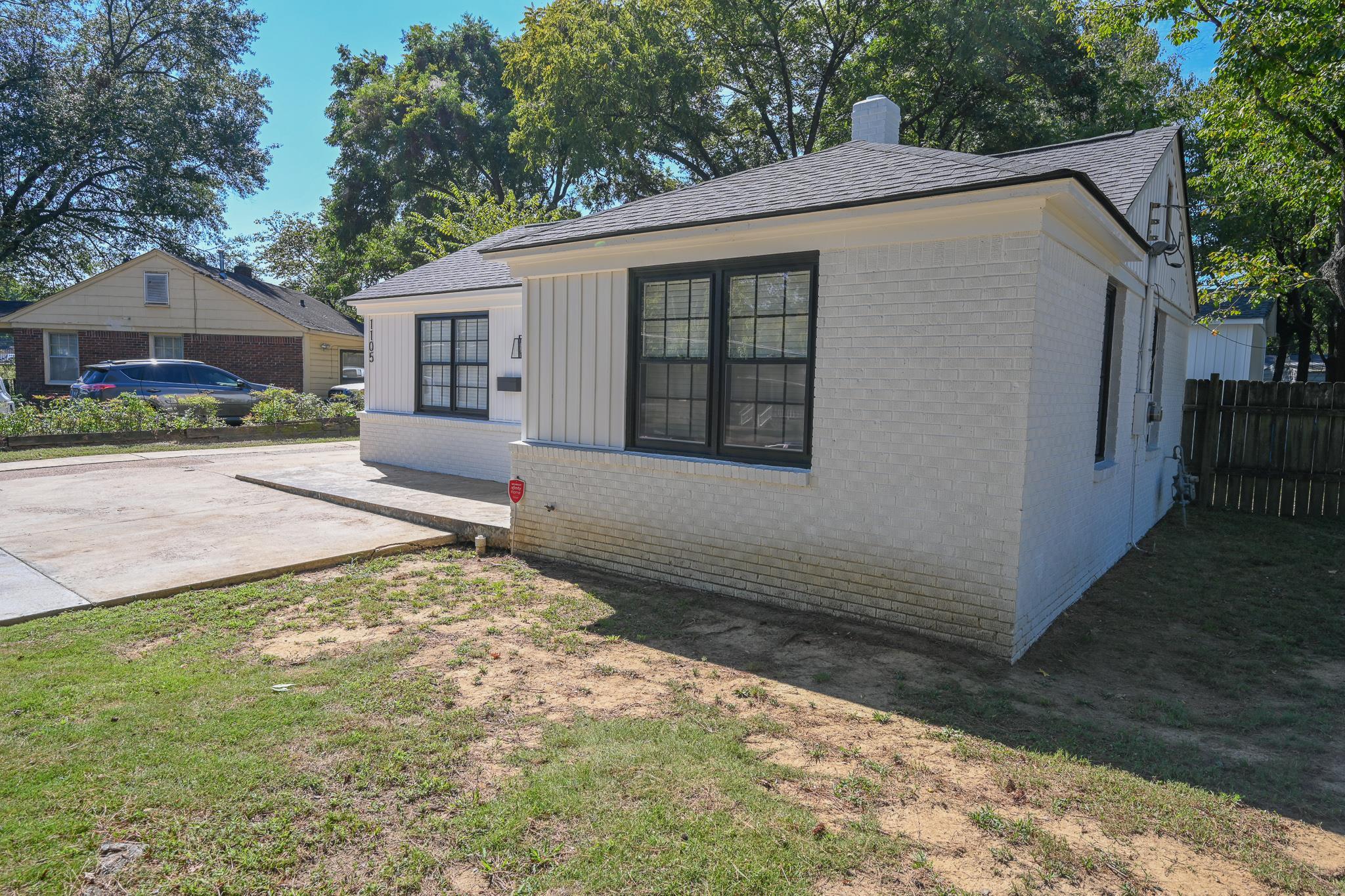 1105 Stratford Road Memphis, TN 38122 - Photo 4 of 26 View of property exterior featuring brick siding, a chimney, roof with shingles, and board and batten siding