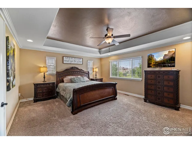 a spacious bedroom with a bed and a flat screen tv
