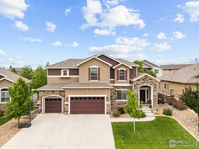 a front view of a house with a garden and yard