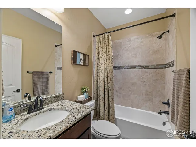 a bathroom with a granite countertop sink mirror bathtub and shower