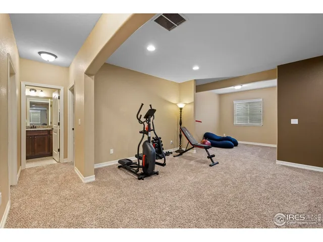 a living room with furniture gym equipment and a ceiling fan