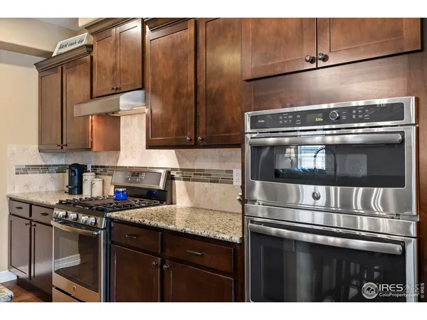 a kitchen with granite countertop a stove and cabinets
