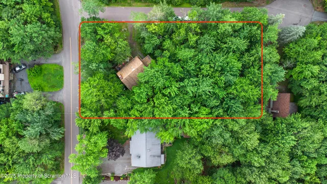 an aerial view of residential houses with outdoor space and trees