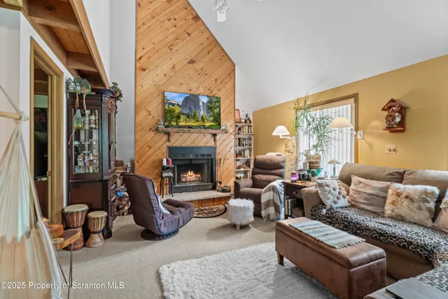a living room with furniture a fireplace and a large window