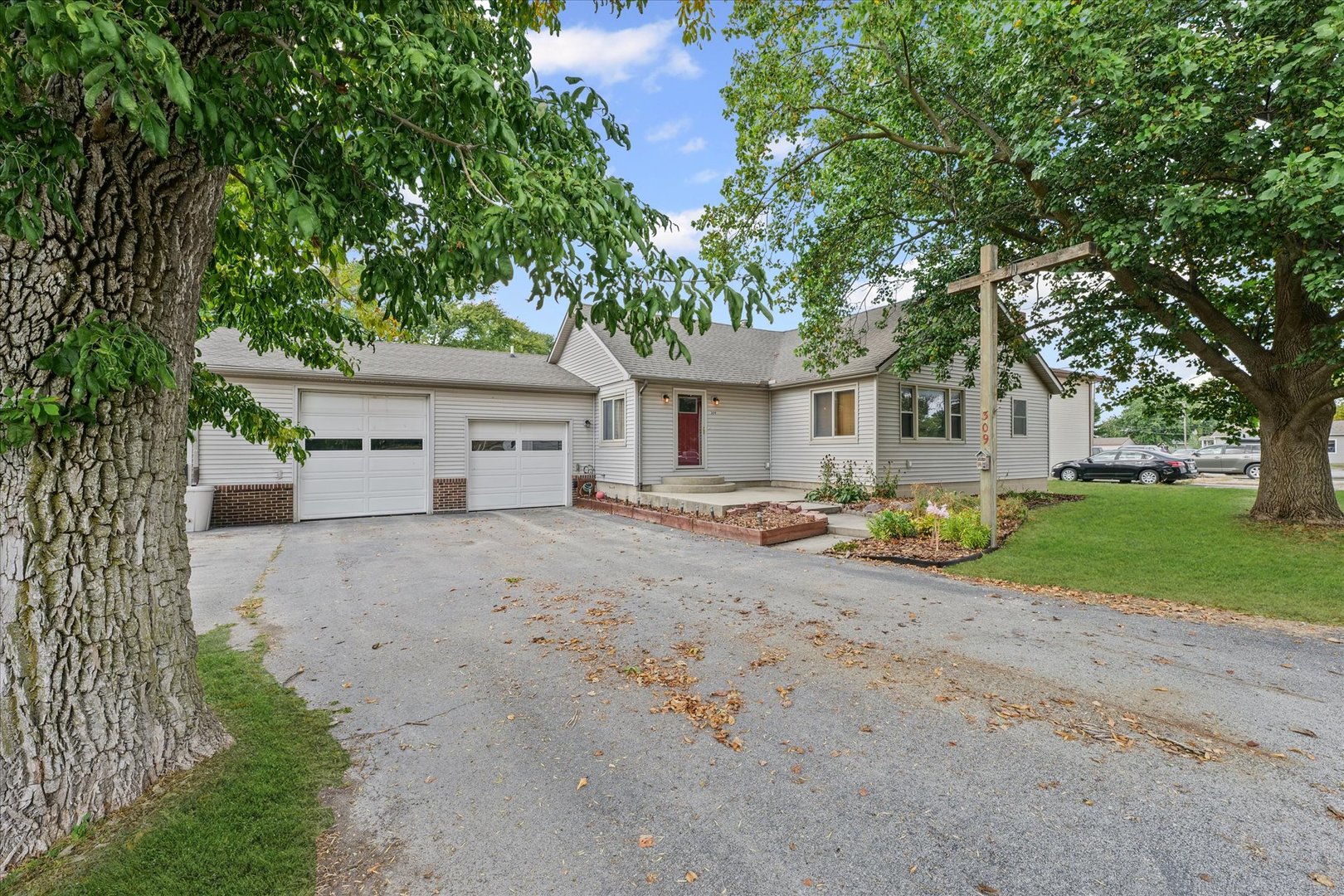 a view of a house with a yard and large tree