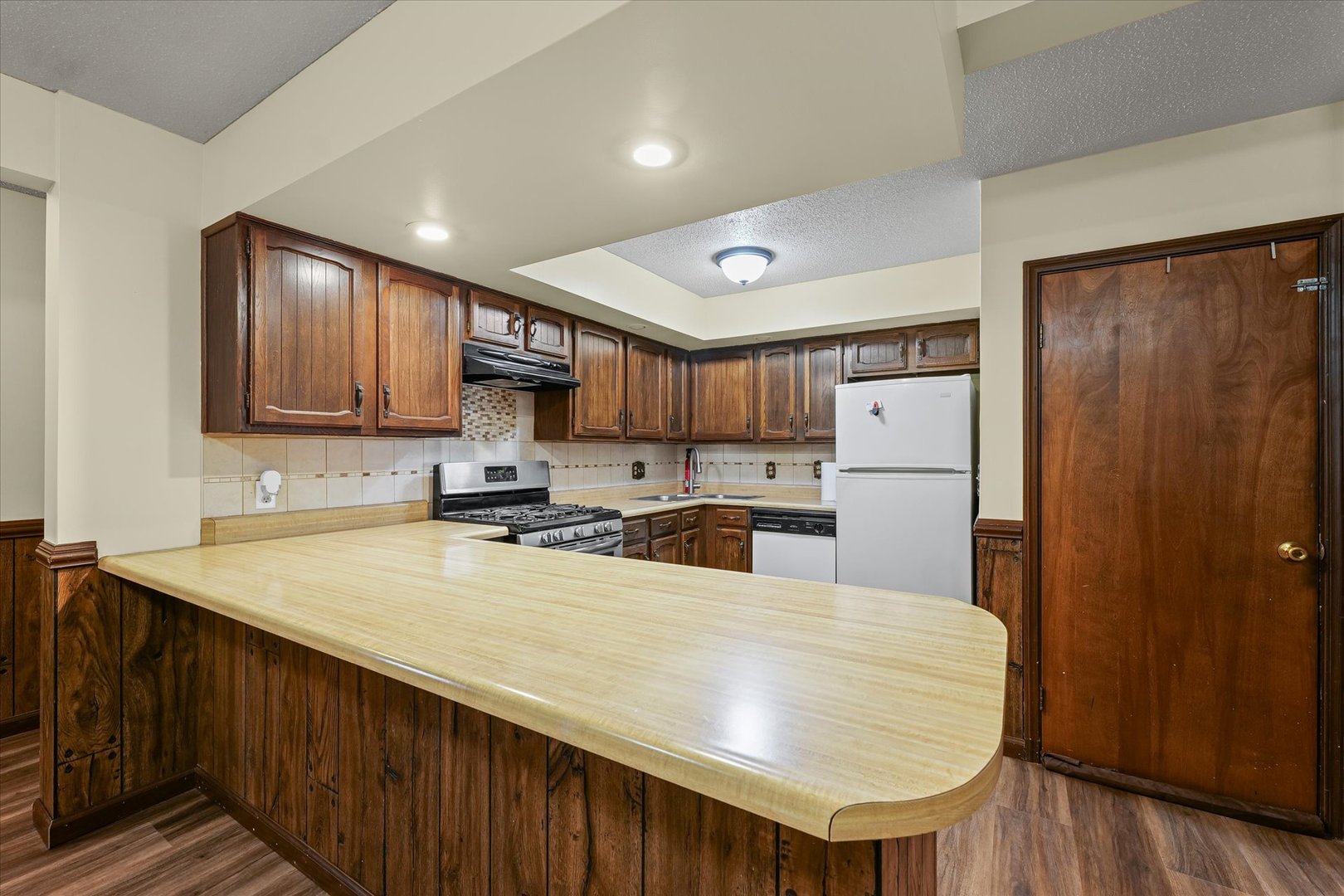 309 North Watson Street Tolono, IL 61880 - Photo 11 of 33 a kitchen with stainless steel appliances granite countertop a refrigerator a sink dishwasher a stove with wooden cabinets and wooden floor