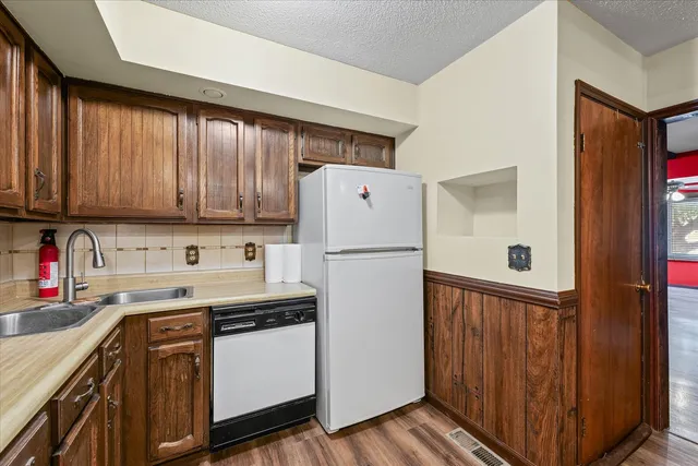 a kitchen with a sink a refrigerator and cabinets