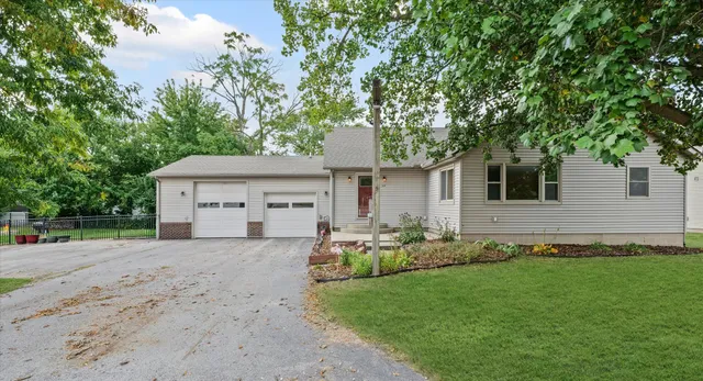 a front view of a house with a garden and yard