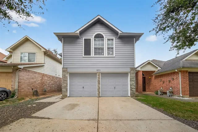 front view of a house with a yard and garage
