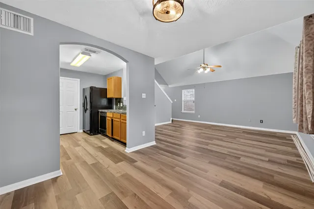 a view of a kitchen with wooden floor and a refrigerator