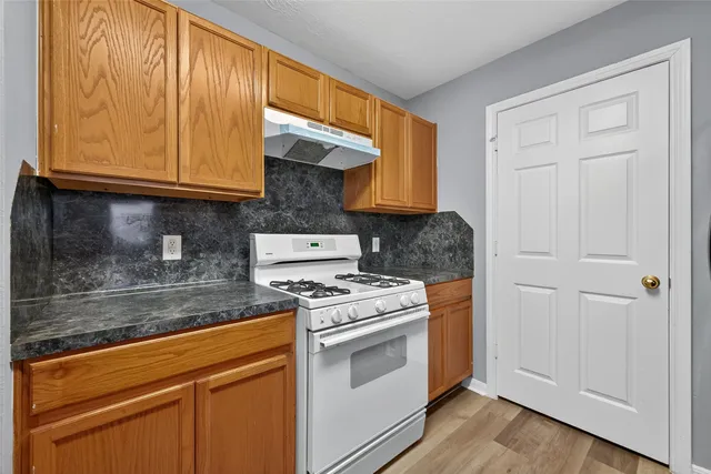 a kitchen with granite countertop cabinets stainless steel appliances and a counter space