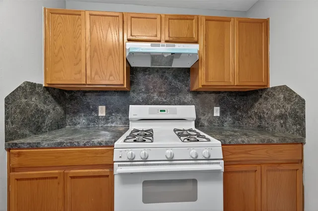 a kitchen with granite countertop cabinets stainless steel appliances and wooden cabinets