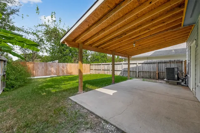 a view of a backyard with floor to ceiling window and wooden fence