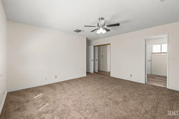 a view of an empty room with a ceiling fan
