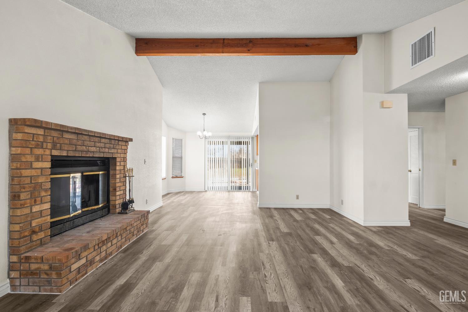 Undisclosed Address Ridgecrest, CA 93555 - Photo 7 of 28 a view of empty room with wooden floor and fireplace