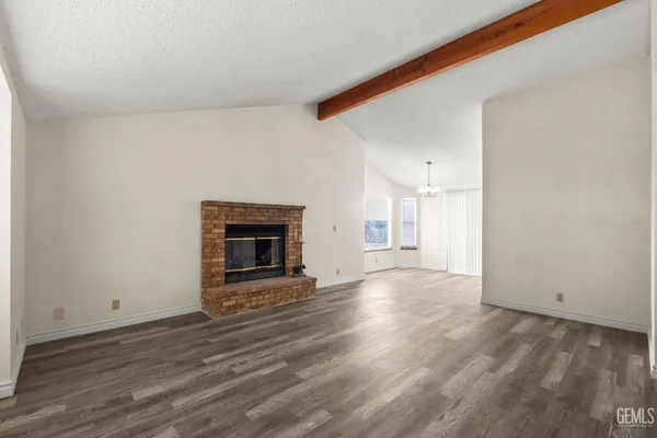a view of a livingroom with wooden floor and a fireplace