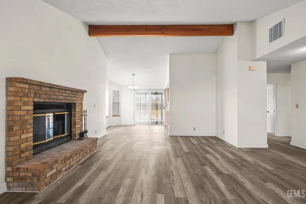 a view of empty room with wooden floor and fireplace