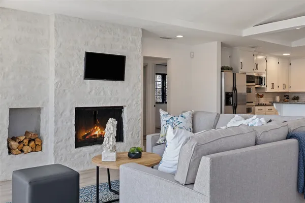 a living room with furniture a flat screen tv and a fireplace