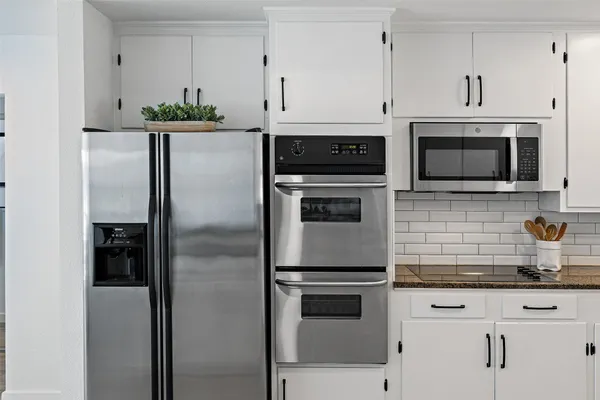 a kitchen with stainless steel appliances granite countertop a refrigerator and a stove top oven