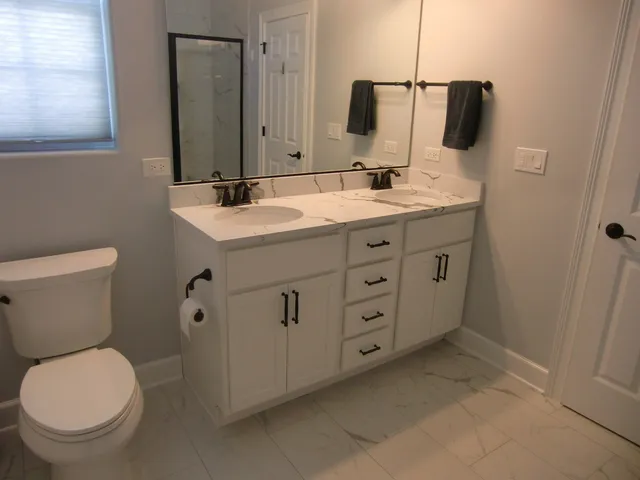 a bathroom with a sink a toilet and mirror