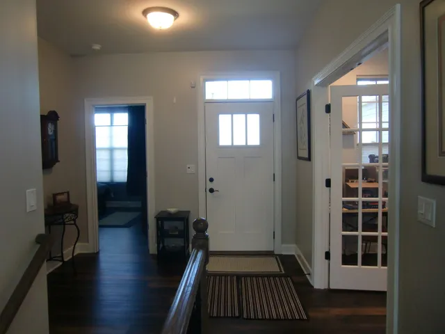 a view of a hallway with wooden floor and stairs