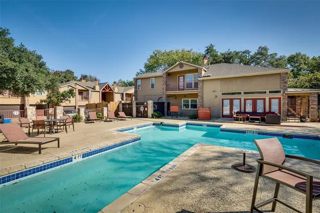 a swimming pool view with a seating space and a garden view