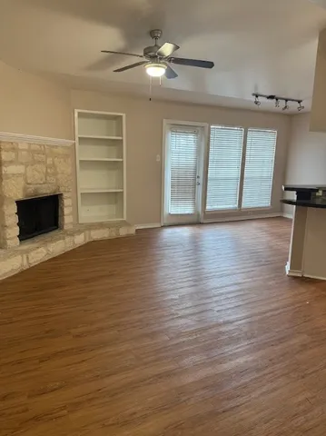 a view of empty room with wooden floor and fireplace