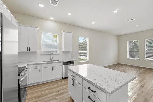 a kitchen with a sink stove and cabinets