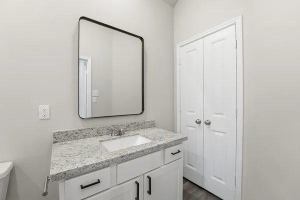 a bathroom with a granite countertop sink and a mirror